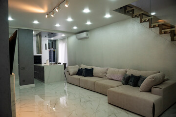 Living room. Light. There is a large sofa in the living room.