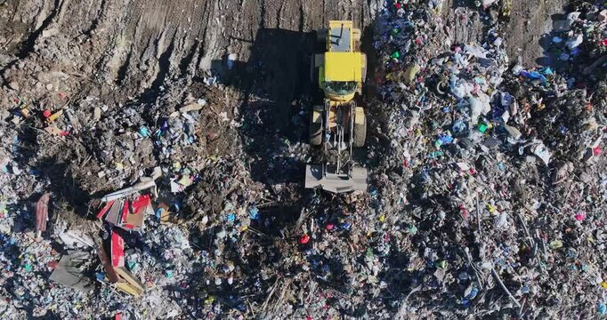 An excavator cleans garbage at a landfill