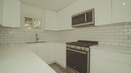 Modern white kitchen with subway tile backsplash, stainless steel appliances, and quartz countertops.