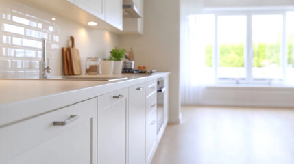 Bright white kitchen featuring sleek cabinetry, marble counters, sunlit space with verdant garden view streaming through expansive window