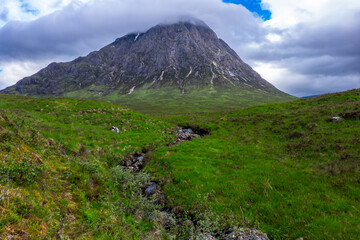 Fototapeta premium Small stream leading to mist covered mountain