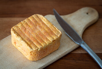 Limburger or Herve cheese close up on wooden plank