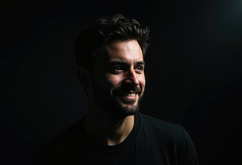 Fototapeta premium A portrait of a smiling man, dimly lit against a dark background.
