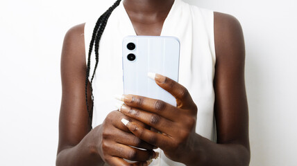 Young black African lady woman in white sleeveless blouse shirt holding in hand mobile cell phone...