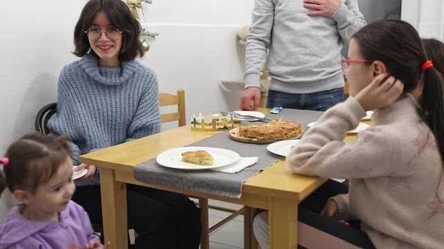 A little girl distributes royal galettes to the family.