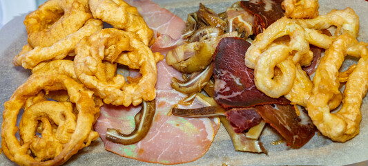 Variety of traditional cured meats and crispy snacks served on a platter