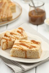 Delicious caramel puffed rice bars on white wooden table, closeup