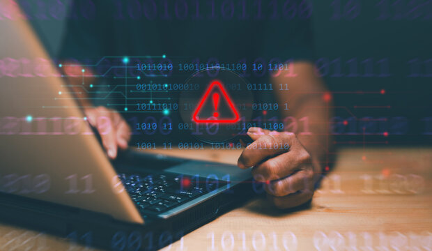 Cyber security concept, Man holding magnifying glass with caution warning sign for notification error maintenance and virus detected, Ransomware, Spyware, Hacker attacks. Detection dangerous worms.