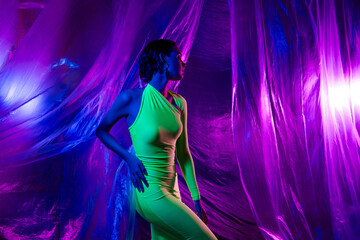 Photo of pretty model girl dance posing green dress isolated on neon studio curtain background