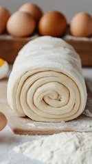 puff pastry rolled up, eggs in the background, close-up