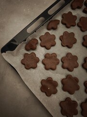 Chocolate flower shaped cookies baking on parchment paper in prague christmas time copy space