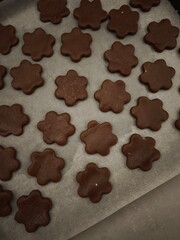 Chocolate flower shaped cookies baking on parchment paper in prague christmas time