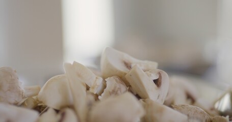 Chef pours sliced mushrooms into a bowl