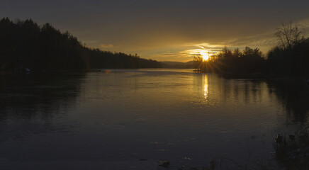 Sunset over a river with some clouds in the sky