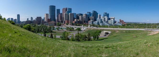 Panoramic city skyline in Calgary, Alberta during summer time with beautiful blue sky day Centre St Bridge in view.