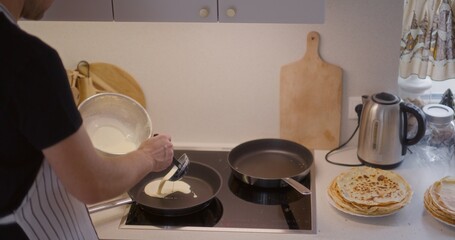 Man Pours Pancake Batter in Pan and Fry Pancakes