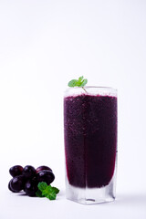 a glass of black grape juice on a white background.