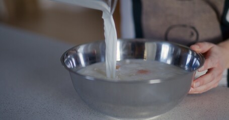 Pouring Milk Into Bowl While Making Dough Close-Up