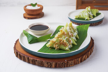 Lupis, is a traditional Indonesian snack made from sticky rice, wrapped in banana leaves, in a...