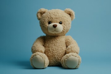 Obraz premium A plush teddy bear sitting against a blue background, conveying warmth and comfort.