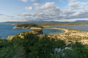 Idyllic voidokilia beach with turquoise colored water and Gialova Lagoon from high point of view on a sunny spring day, Messinia, Peloponnese, Greece