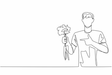Single one line drawing man holding some carrots with the tips of the leaves still thick. Plays role in bone health. Carbohydrate. International Carrot Day. Continuous line design graphic illustration