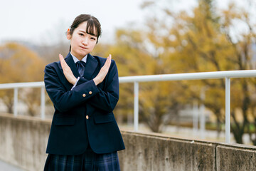 手でバツを作る制服姿の高校生・中学生・女子高生
