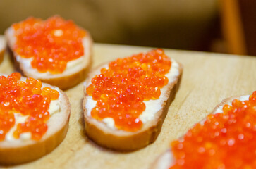 A close-up image of several toasts with red caviar spread on top.