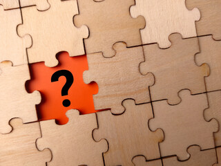 Black question mark placed on last piece of jigsaw puzzle