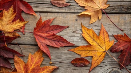 Obraz premium Autumn leaves with vibrant hues of red, orange, and yellow, scattered across a weathered wooden surface, capturing the essence of the season's transition.