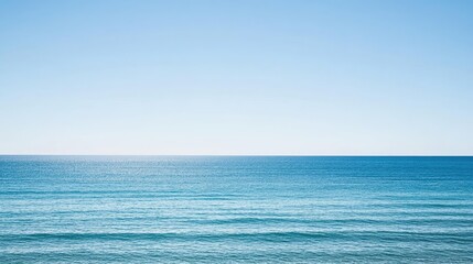 Naklejka premium Calm Blue Ocean Under Clear Sky with Gentle Waves and Tranquil Atmosphere