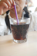 A Happy Child is Enjoying a Refreshing Drink with a Purple Straw