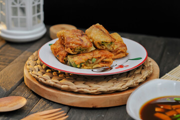 Egg martabak with vinegar sauce is served on a white plate