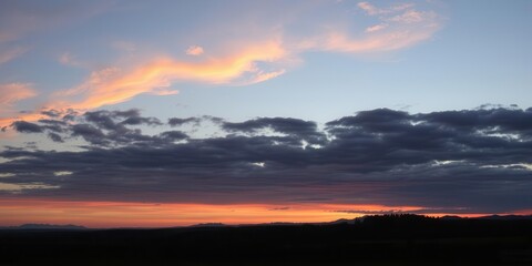 Panoramic view of a peaceful nature scene with a colorful sky and mountains in the background, tranquil, dawn, dusk