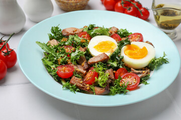 Delicious fresh tuna salad and ingredients on white tiled table, closeup