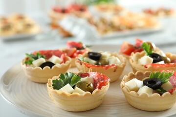Many tasty canapes on white table, closeup