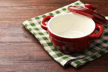 Ceramic casserole and lid on wooden table, closeup. Space for text