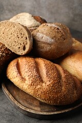 Different freshly baked bread loafs on grey table, closeup