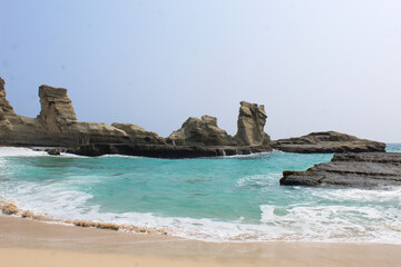View of the crashing waves washing the beach, with a very beautiful cliff background on Klayar Beach, Pacitan.