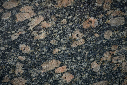 Granite stone showing pink feldspar crystals embedded in dark matrix