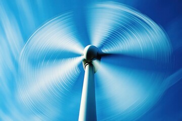 A close-up of a wind turbine's rotor spinning, with the blue sky as a backdrop. The motion blur of the blades captures the dynamic energy production process. This image emphasizes the engineering
