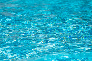 Blue water reflection. Blue pool waves. Swimming pool. Water surface. Blue water texture. Close up blue water surface. Textured background.