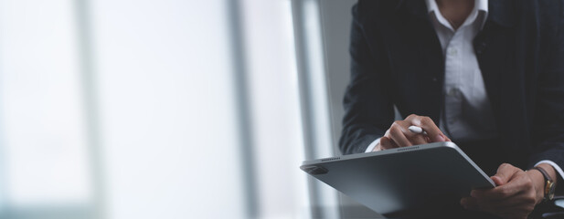 Close up, business woman using stylus pen signing e-document on digital tablet via mobile app at...