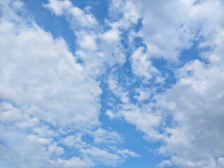 clear blue sky with a few clouds. The sky is very bright and the clouds are scattered throughout