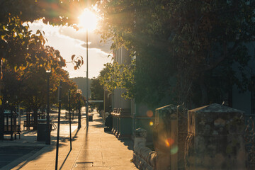 Empty footpath in town illuminated by golden afternoon light