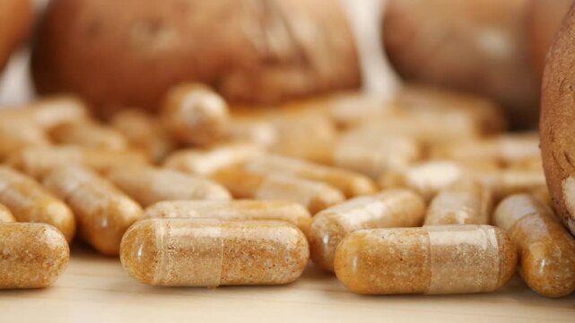 Close-Up of Mushroom Capsules and Fresh Mushrooms on a Wooden Surface
