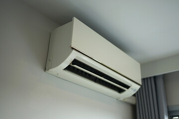 Wall-mounted air conditioner in a modern interior with furniture and natural light
