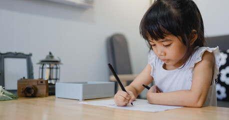 Naklejka premium Child drawing with pencils and chalk on the floor at home while studying and playing
