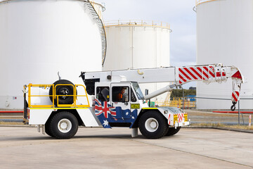 Male worker driving a white pick and carry crane truck