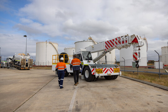 Workers walking towards the side of the cherry picker truck.